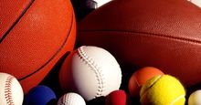 Assorted sports balls including a basketball, football, soccer ball, tennis ball, baseball and others.