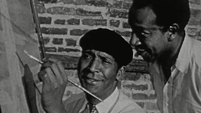 See Palmer C. Hayden demonstrating his painting technique to another artist